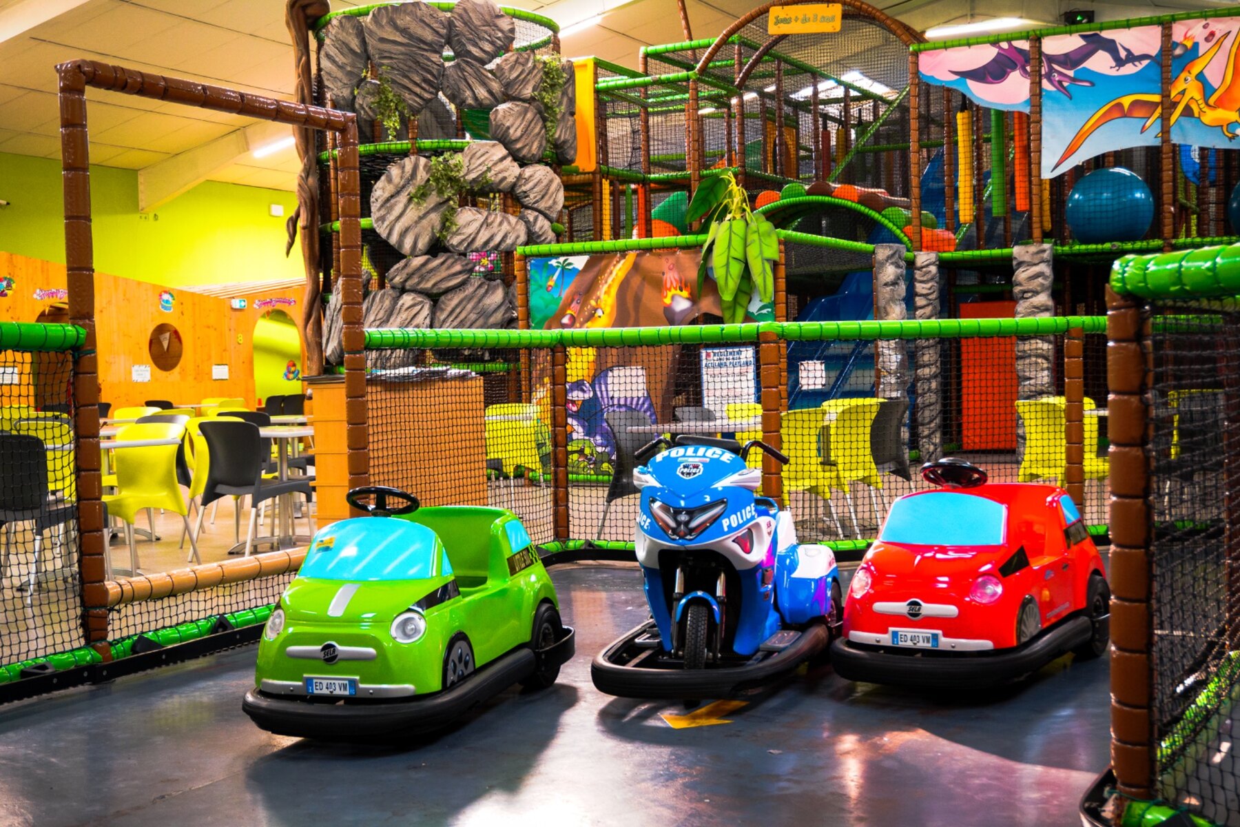 Mini-karts devant les décors de dinosaures et la structure de jeux