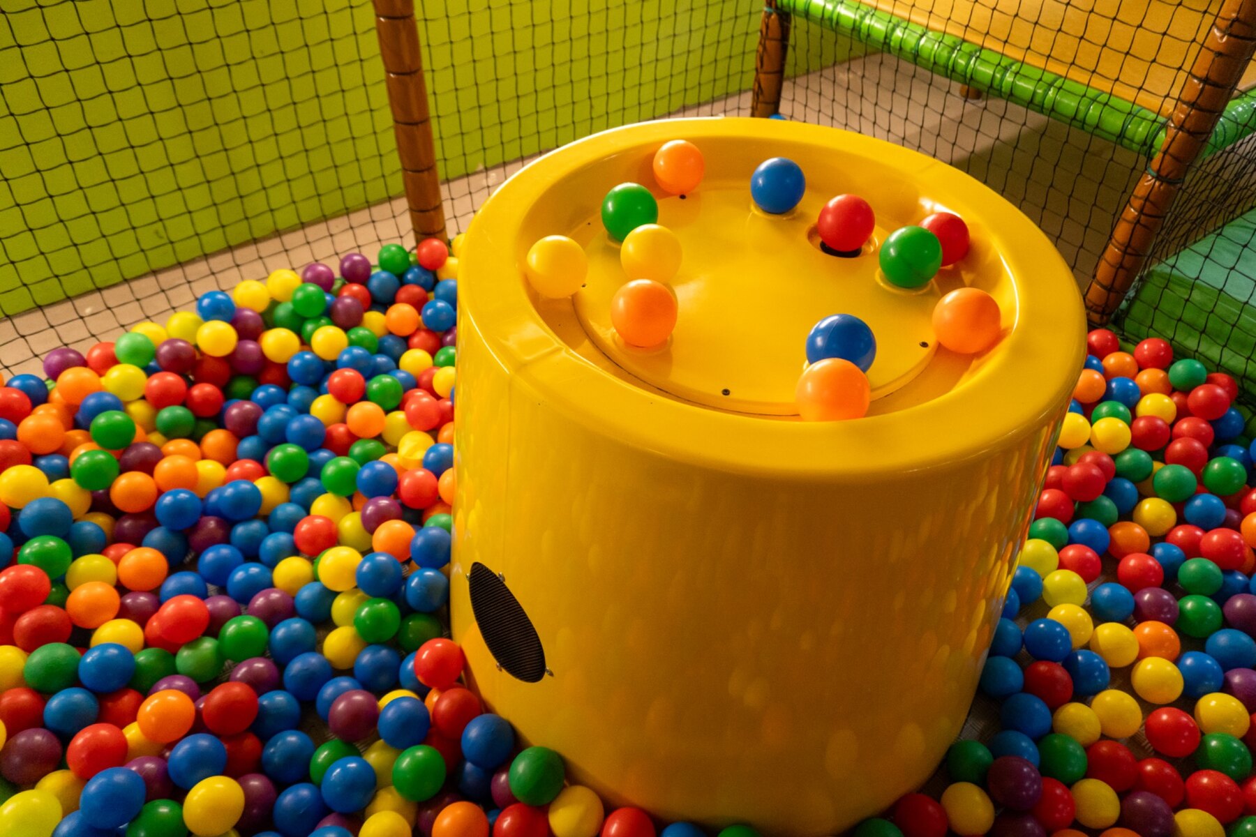 Jeu jaune au milieu des balles colorées de la petite structure