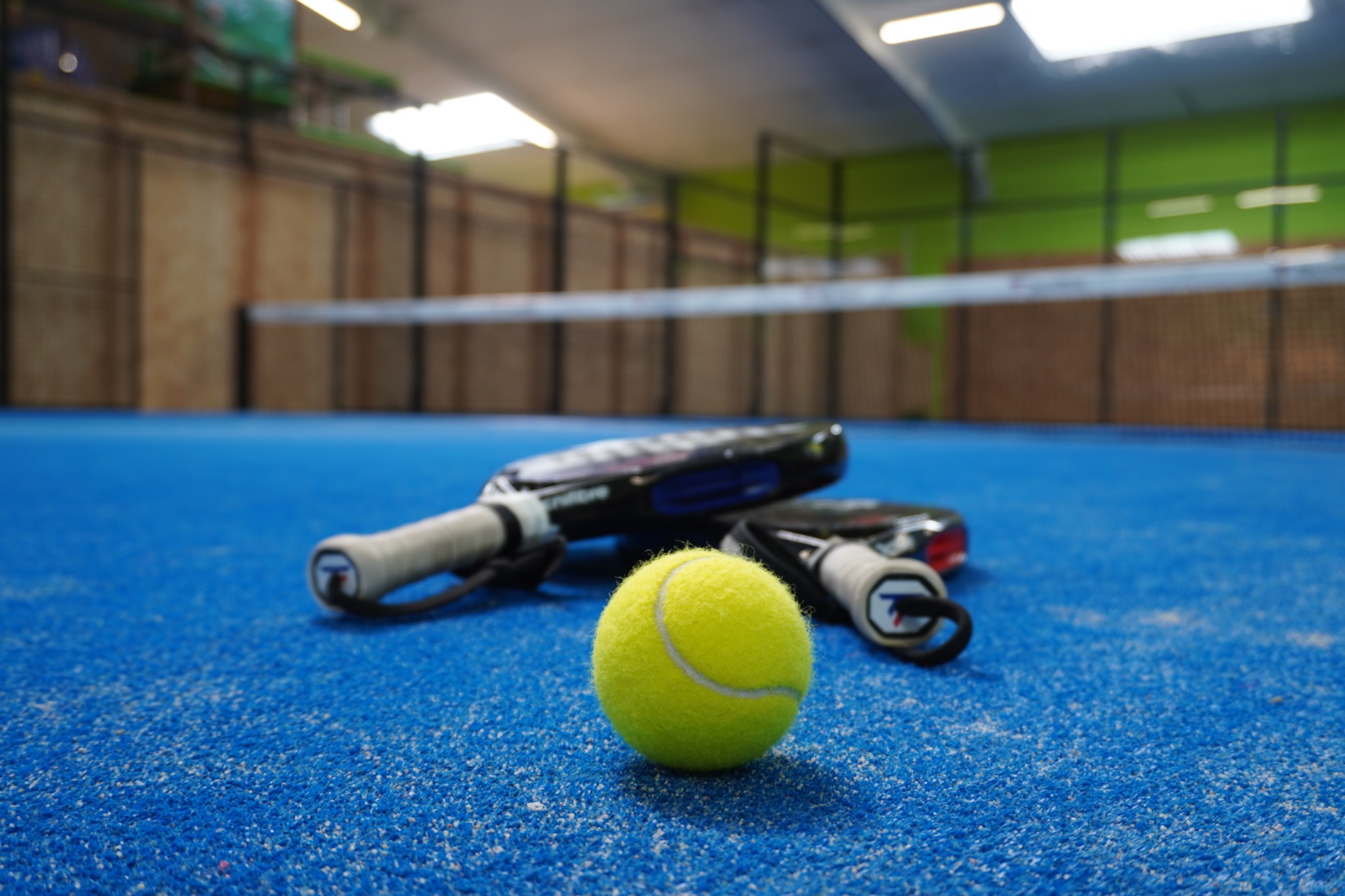 Raquettes et balle sur un court de Padel chez Pad&Ball